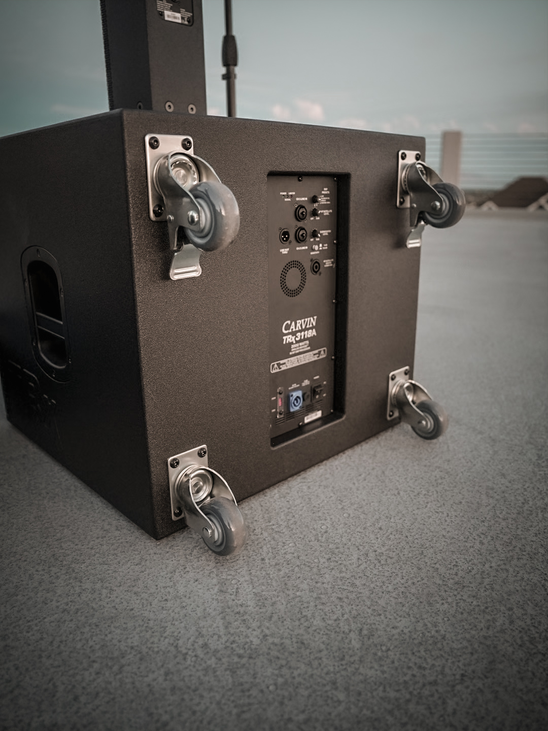 Rear panel and caster wheels of a Carvin TRx3118A powered subwoofer