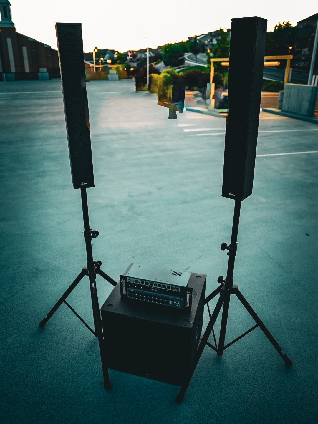 Column array speakers raised on stands for even coverage of an outdoor space