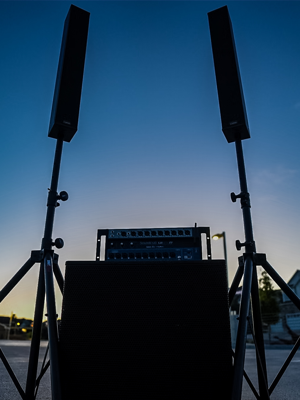 Column array speakers silhouetted against a blue twilight sky