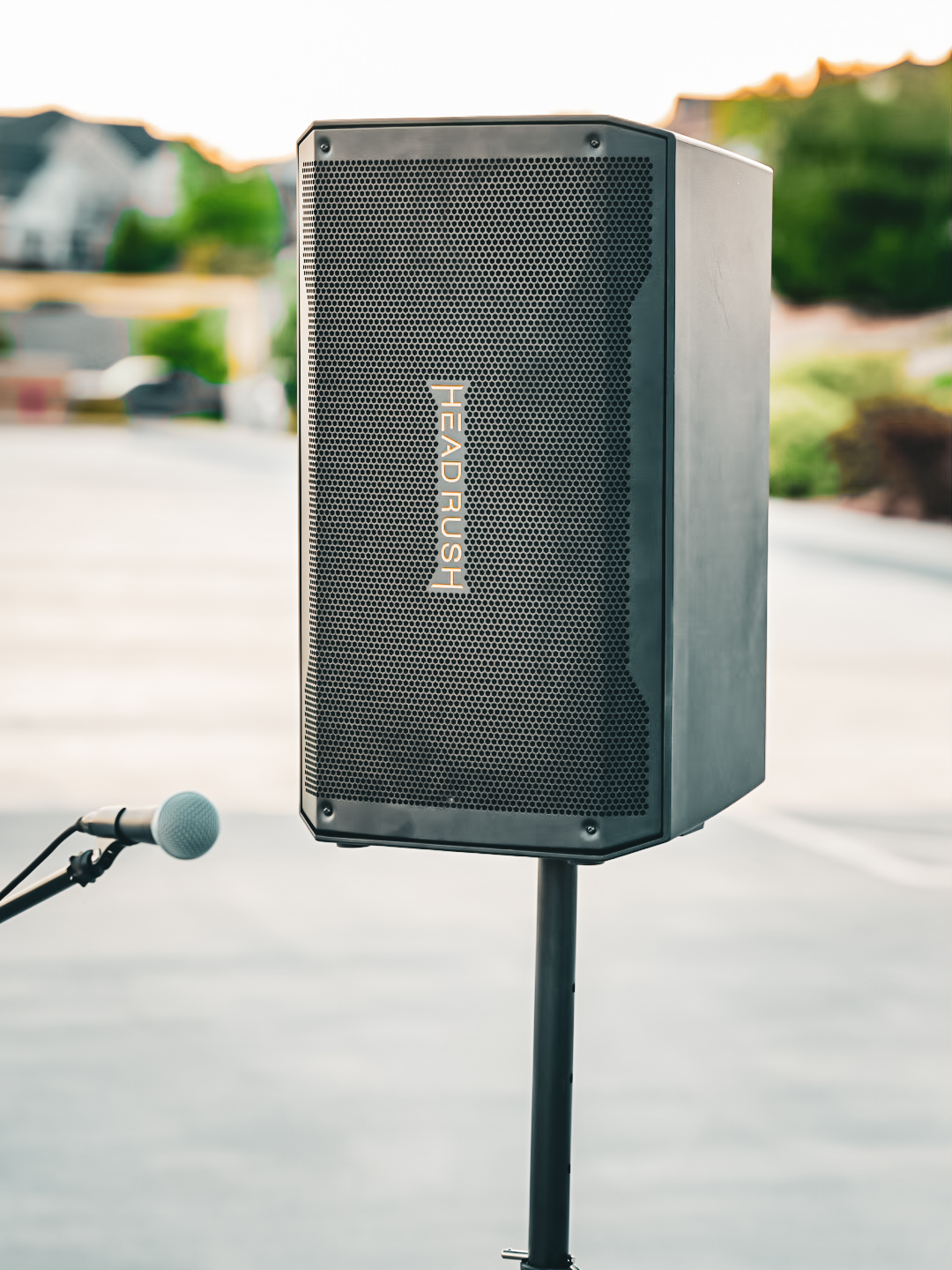 A HeadRush FRFR-112 powered speaker mounted on a speaker stand