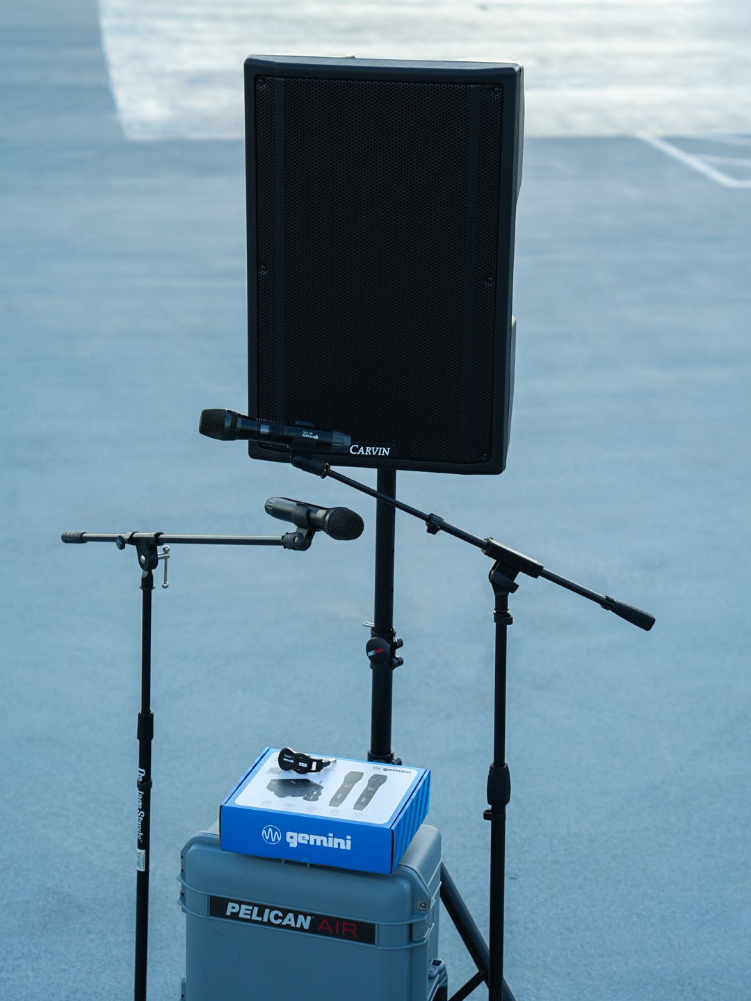 A Carvin speaker with a Gemini wireless microphone system on a Pelican Air case