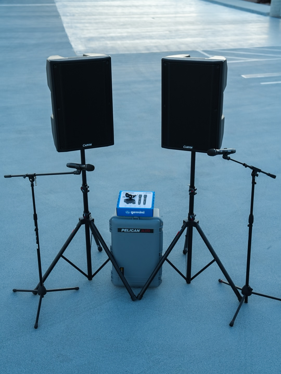 A stereo pair of Carvin speakers with microphone stands, staged and cabled