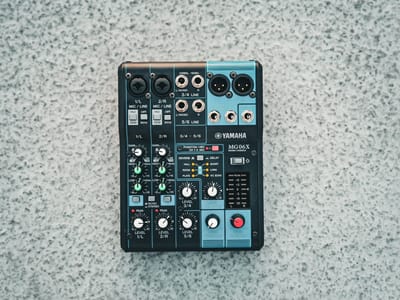 A Yamaha MG06X six-channel analogue mixer viewed from above, showing its gain, EQ, and level controls