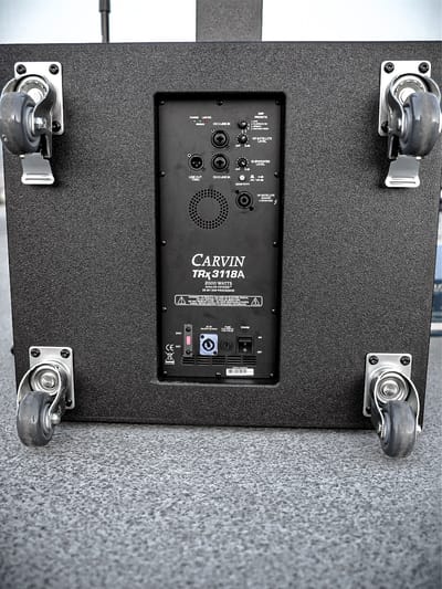 Four heavy-duty caster wheels bolted to the base of a Carvin TRx3118A powered subwoofer